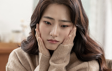 여성이 양손으로 얼굴을 감싼 모습